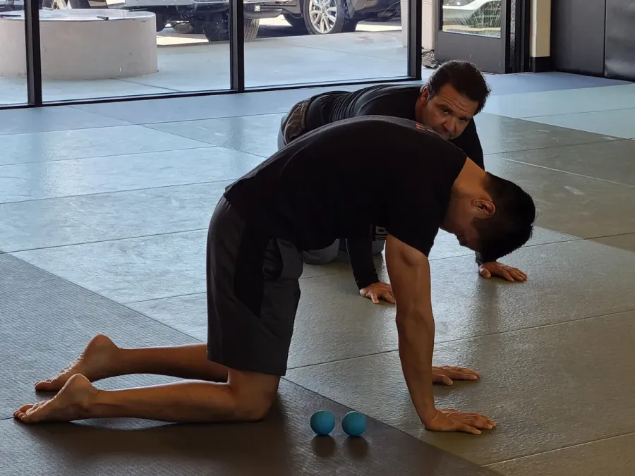 Dr. Phil Yoon coaching a client through a mid-back mobility drill