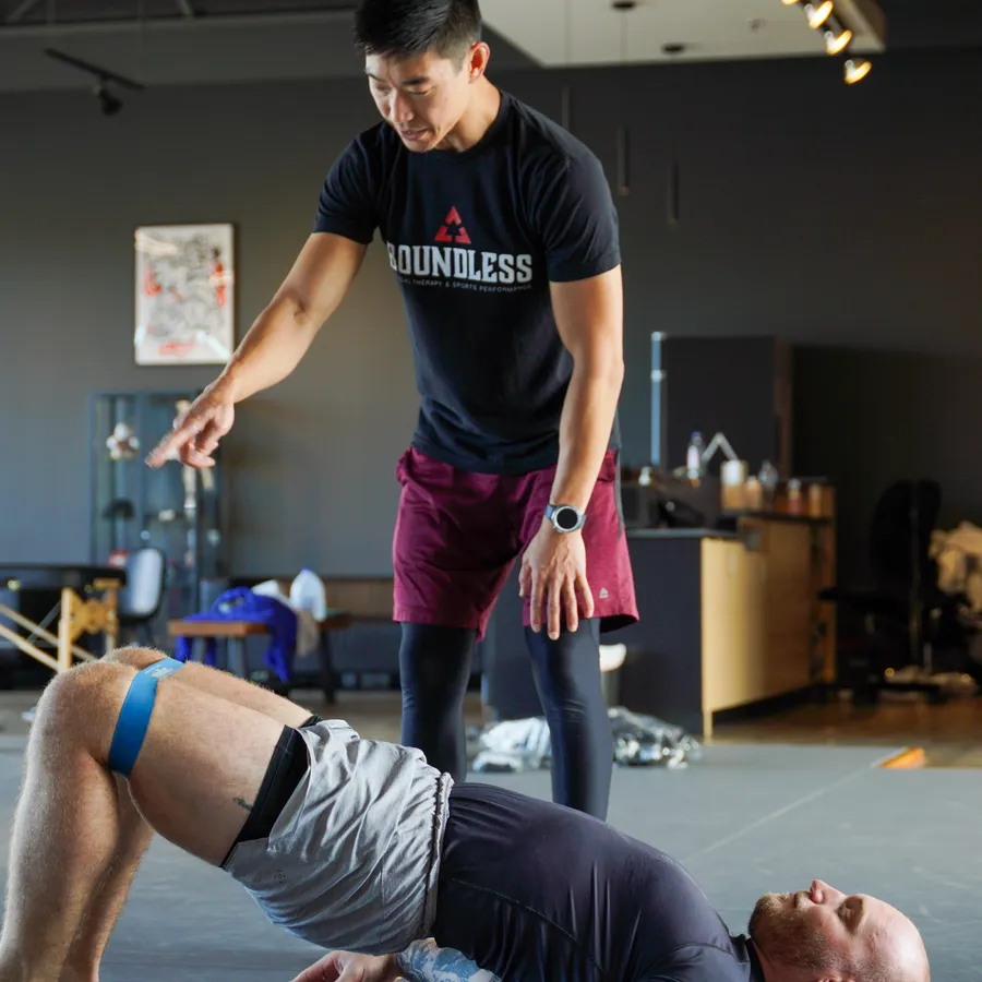 Dr. Phil Yoon guiding a client through a glute bridge